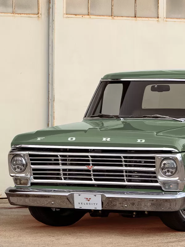 Velocity Ford F-100 restored truck near an industrial door