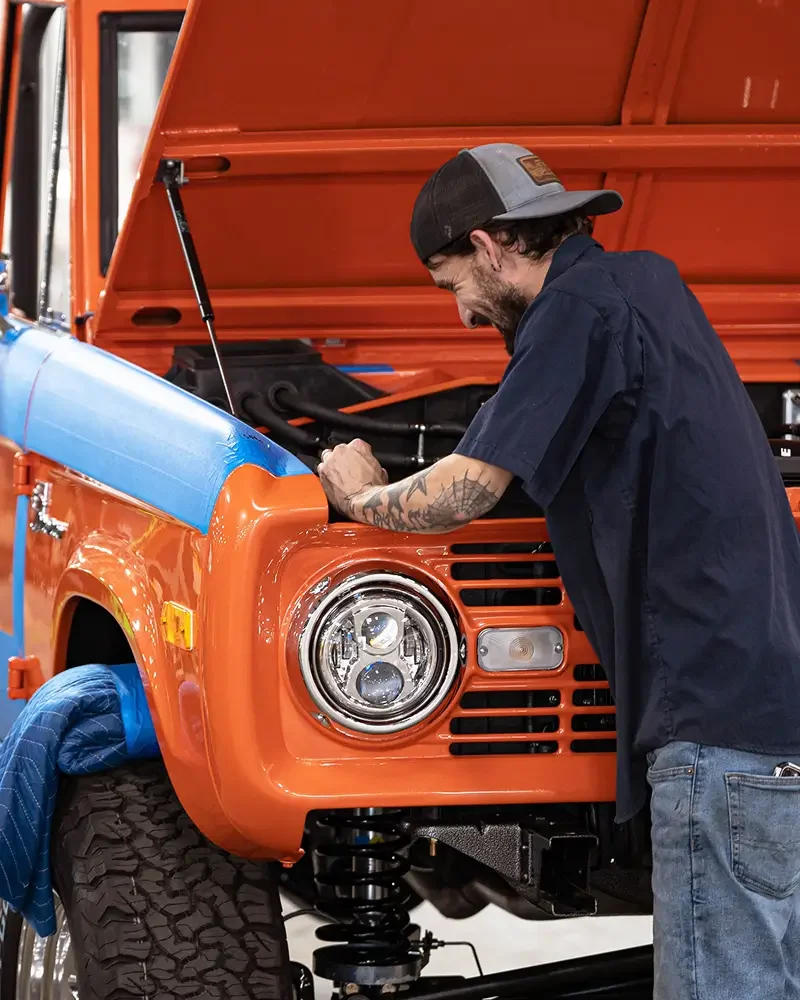 Velocity technician working in the engine bay of a classic bronco