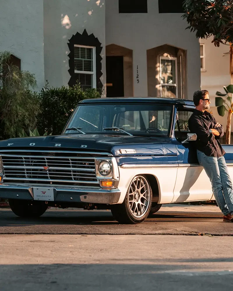 Velocity customer leaning on a newly delivered restored F-100