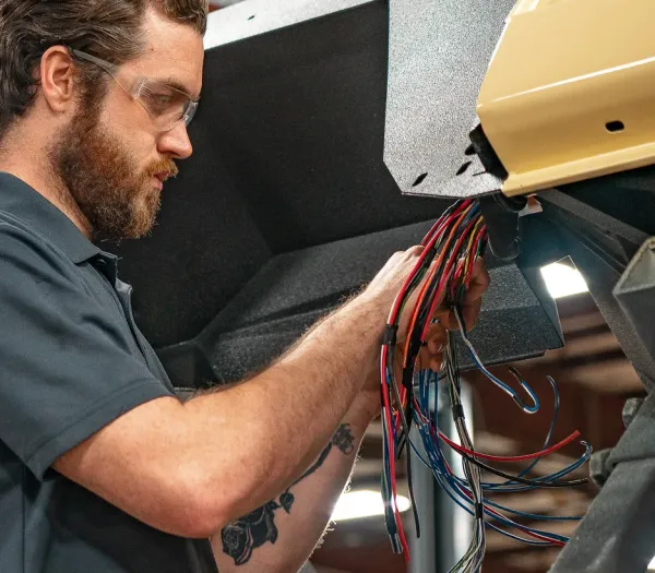 Auto-electrician working on vehicle wiring