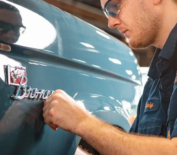 Technician affixing Bronco badge to truck